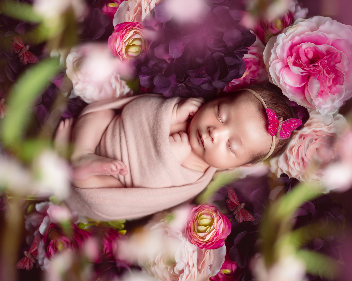 Cute newborn baby girl sleeping on the flowers. Stunning newborn photoshoot in Mequon Wisconsin.