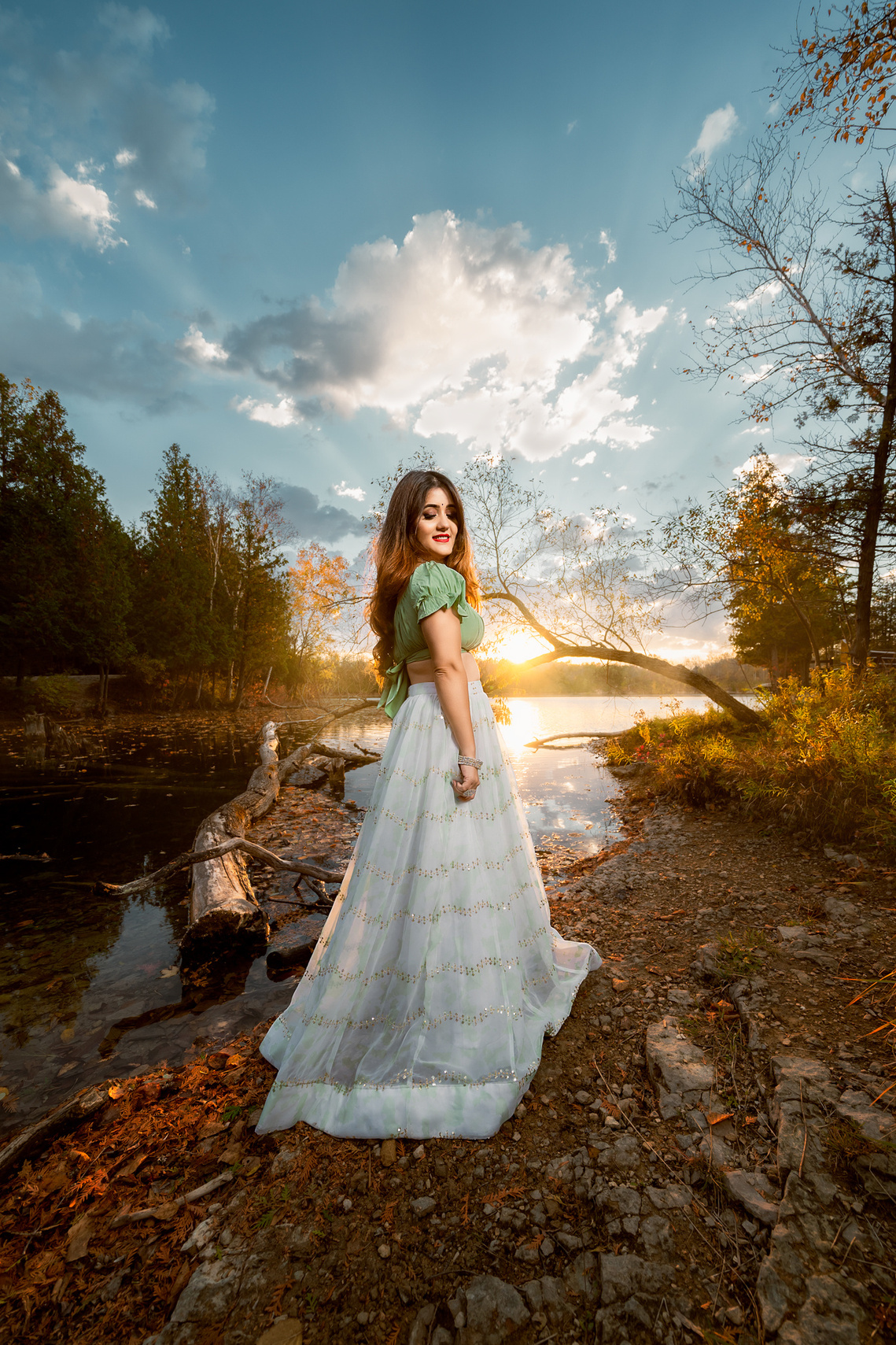 Beautiful lady standing by the lake enjoying the sunset light behind her, stunning location in Harrington Beach Wisconsin. 