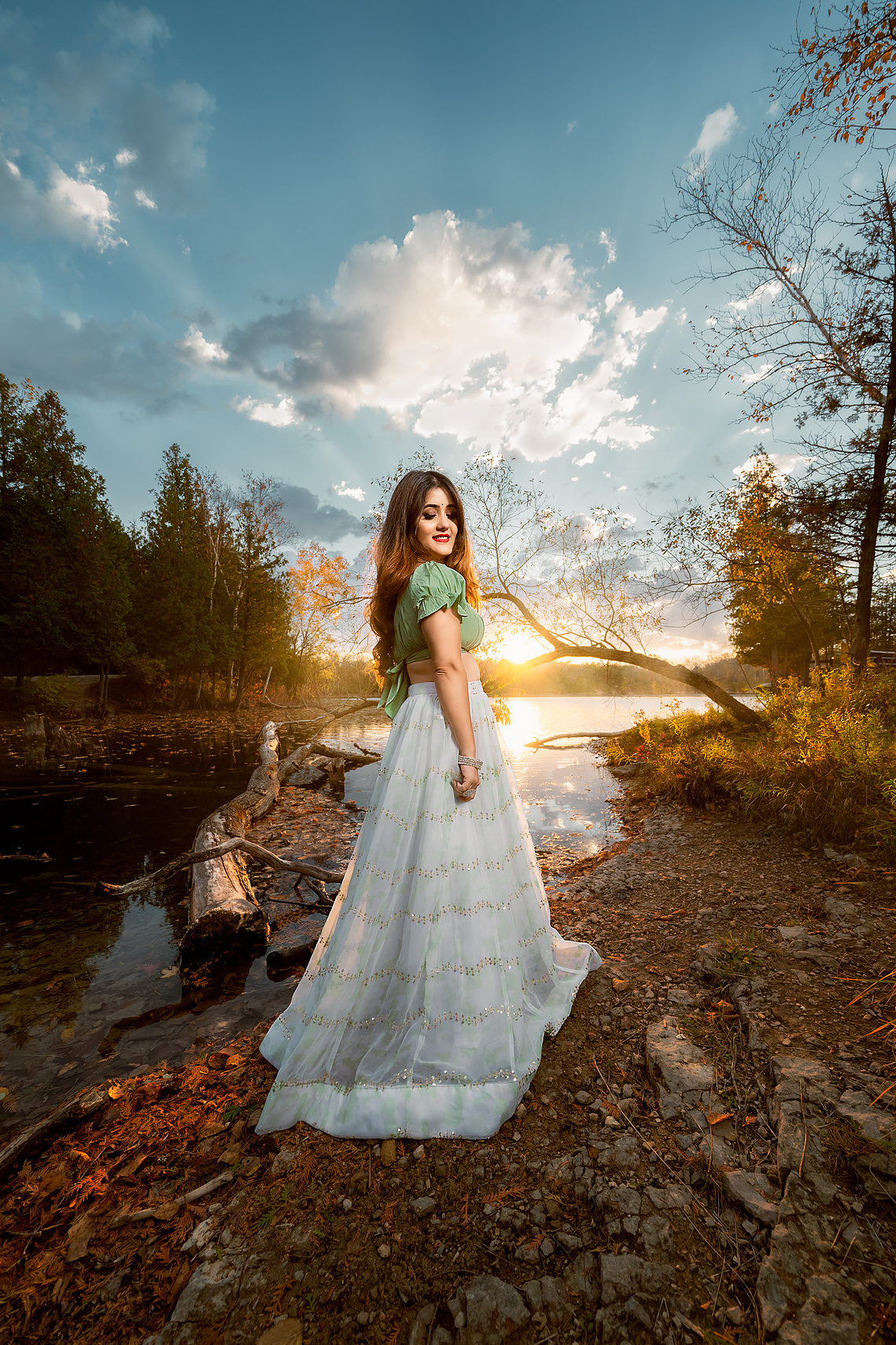 Beautiful lady standing by the lake enjoying the sunset light behind her, stunning location in Harrington Beach Wisconsin. 