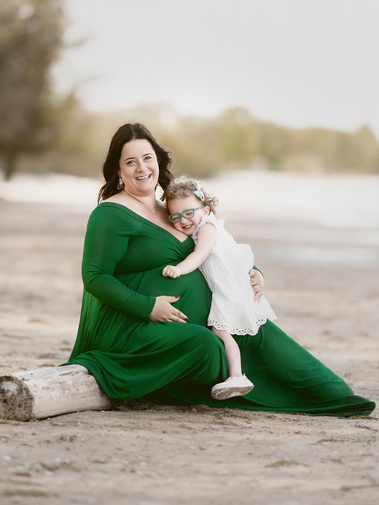Timeless portrait of a pregnant mom and toddler girl by the beach of Lake Michigan. 