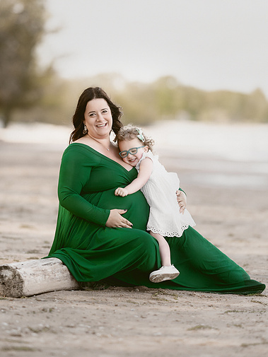 Timeless portrait of a pregnant mom and toddler girl by the beach of Lake Michigan. 