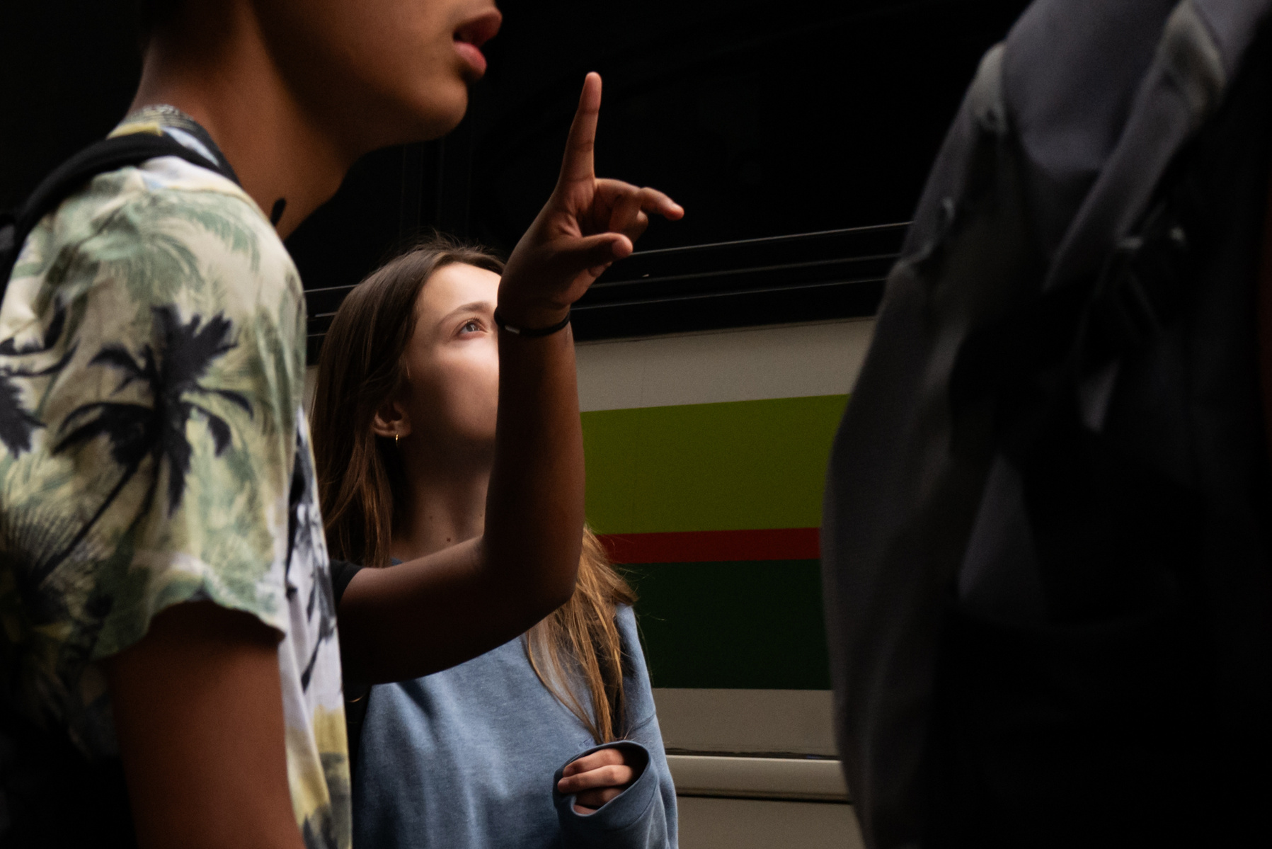 Girl with finger-nose looks up in wonder.