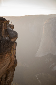 A person stands on the edge of Taft Point overlooking El Capitan.