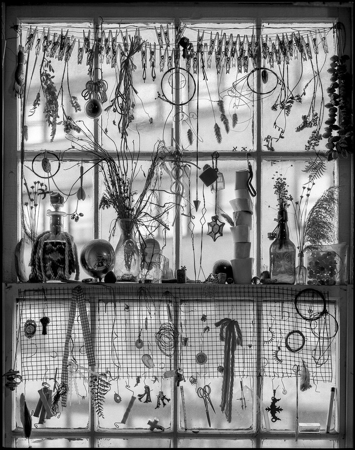 Still life of various objects arranged in a window.