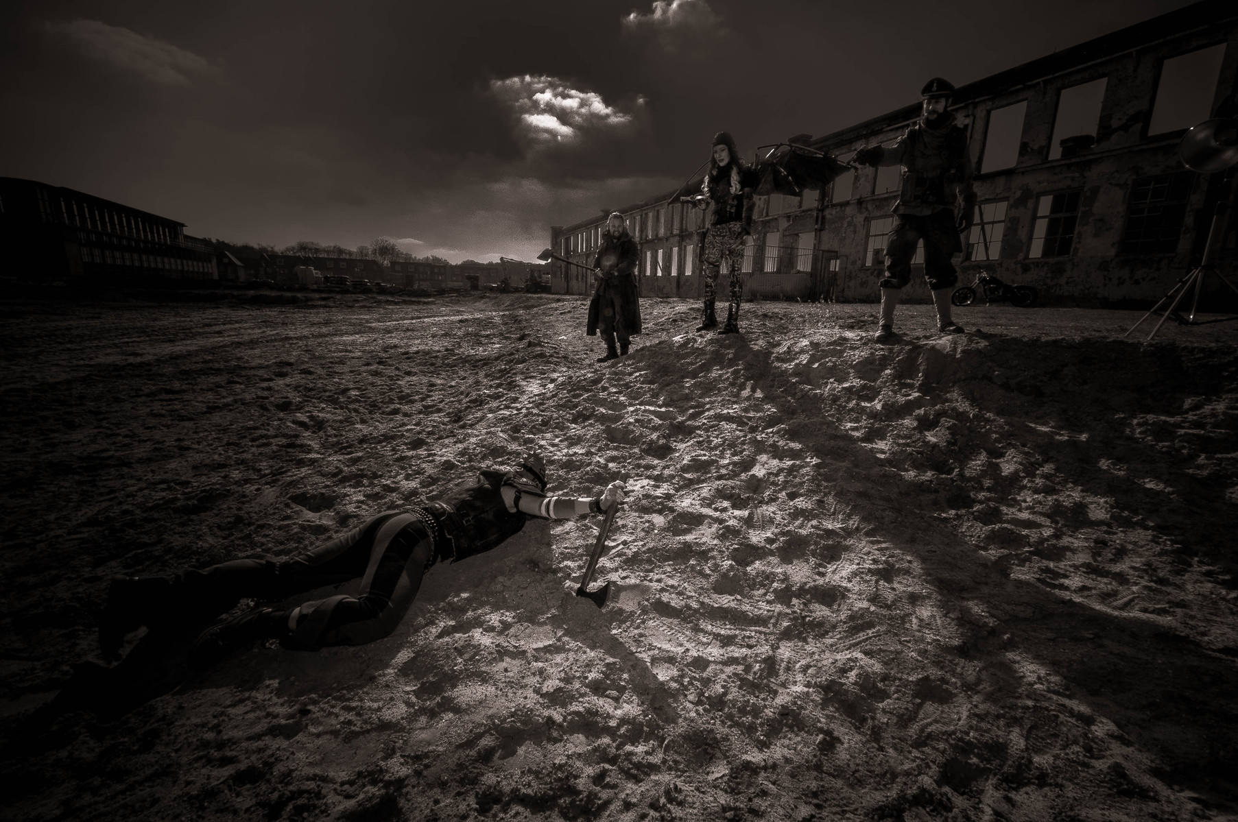 Dieselpunk, black and white, three persons on sand one lays down