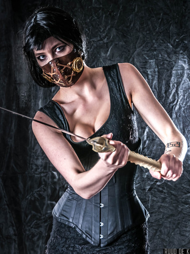Constance Bashford, corset, black hair, holding japanese sword.