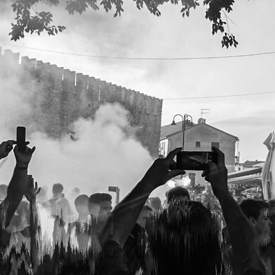 A large crowd on the street at festival busy capturing the moment on the smartphones instead of being present in the moment.