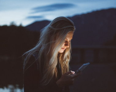 Woman staring at her screen in nature.