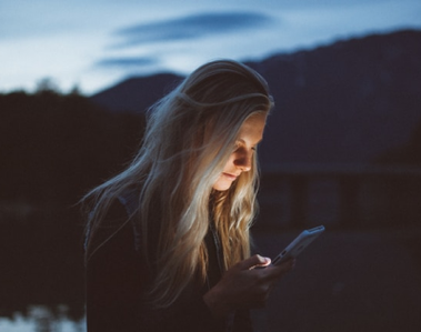 Woman staring at her screen in nature.