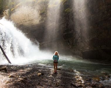 Person being in nature next to waterfall.