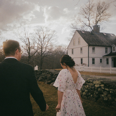 Shot on 35mm Film, bride and goom walking with a perfect sunset, image has deep undertones.