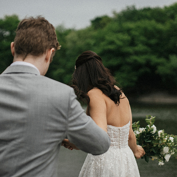 New York City Wedding Photographer
in Central Park. Couple holding hands and walking towards the water in Central Park.