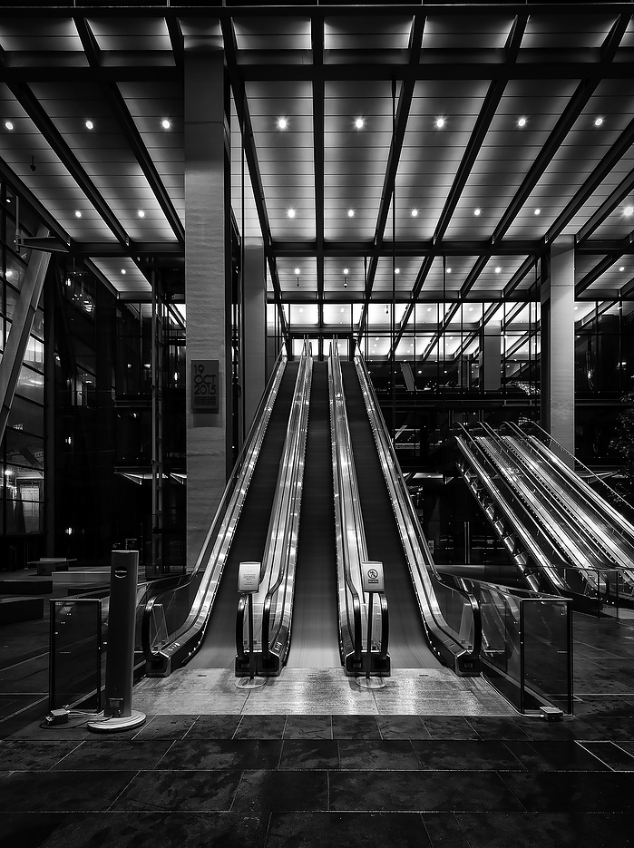 A black and white photo of Lloyds of London's entrance at night by Mark Burley