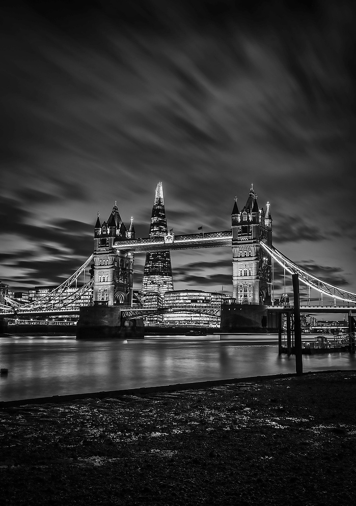 A black and white photo of Tower Bridge and the Shard at night by Mark Burley