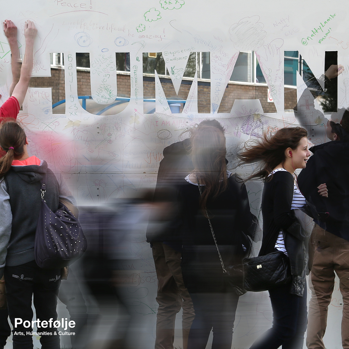 An image of multiple people drawing and writing on the 8 foot by 8 foot piece of MDF with 