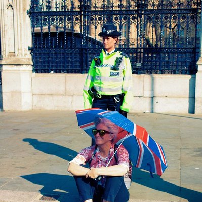 'Woman sitting outside Westminster with an Union Jack umbrella, London Colour Street Photography'