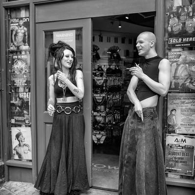 Two people standing outside a shop in Soho, London black-and-white photography