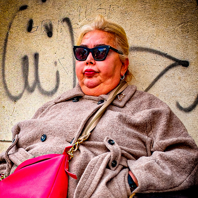A colourful woman sitting outside a shop London colour photography