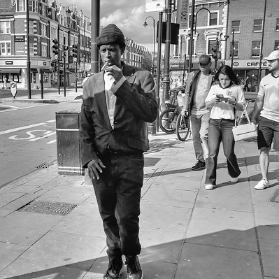 Man walking having a smoke. Tooting Broadway. South London. black & white photography