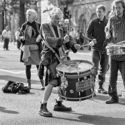 'Protester Playing a Drum at the Extinction Rebellion Protest, London Black and White Street Photography'