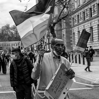 'Pro Palestinian protester walking along Whitehall, Pro Palestinian protests, London Street Photography Black and White'