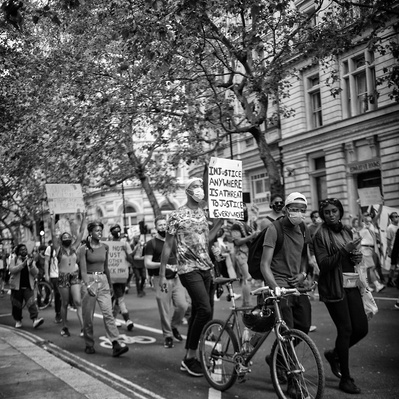 'Black Lives Matter protesters walking through the streets of London holding placards, London Black and White Street Photography'