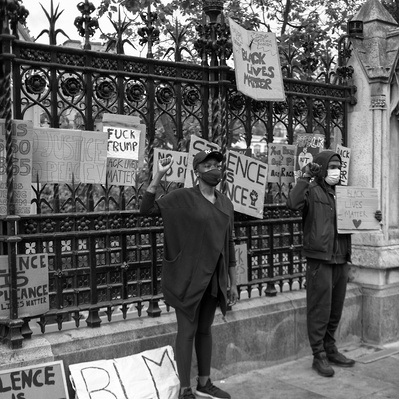 'Protesters holding placards outside houses of parliament at the Black Lives Matter Protest, Black and White London Street Photography'