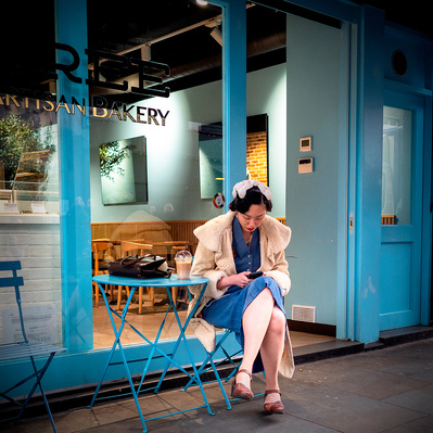 Woman outside a coffee shop, Soho, London,UK