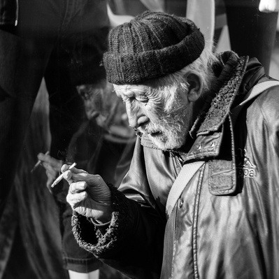 Rough sleeper, enjoying his cigarette London black-and-white photography