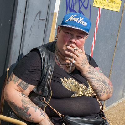 'tattooed women having a smoke tooting, london black and white street photography'