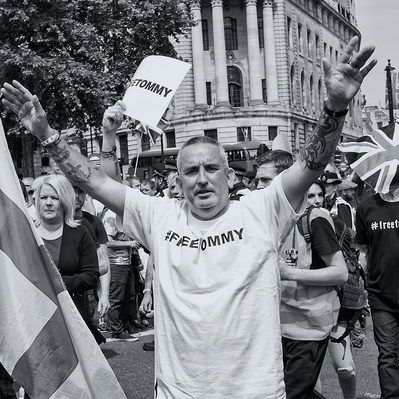 'Tommy Robinson Supporter with his arms in the air, London Black and White Street Photography'