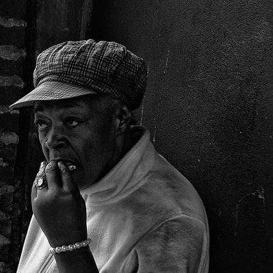 A rough sleeper rolling a cigarette Brixton, London black-and-white photography