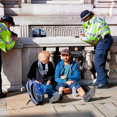 'Two Extinction Rebellion Protesters having their names taken by Met Police Officers, London Colour Street Photography' 