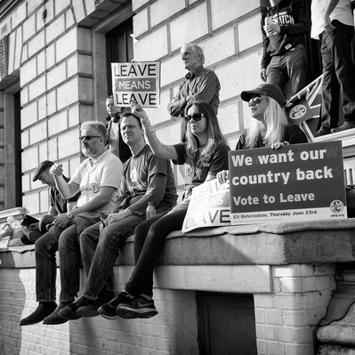 'Pro Brexit supporters sitting on a wall holding placards outside Westminster, London Black and White Street Photography'