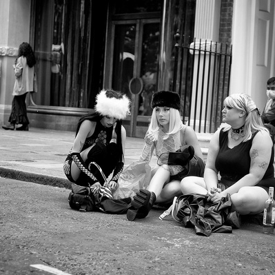 Group of girls sitting on the pavement relaxing Soho, London black-and-white photography