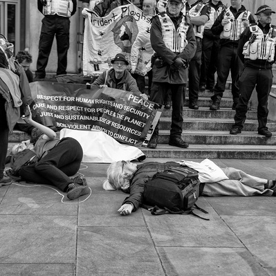 'Extinction Rebellion Protesters laying outside Offices, With Met Police Officers Watching London Black and White Street Photography'