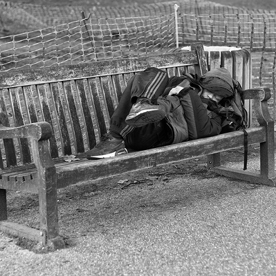 Rough sleeper sleeping on the park bench London black-and-white photograph photography