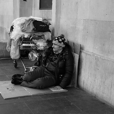 Rough sleeper sitting on cardboard London black-and-white photography