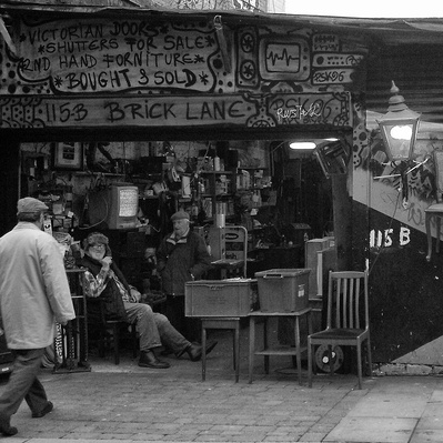 Two men sitting down in their store, brick Lane East London black-and-white photography