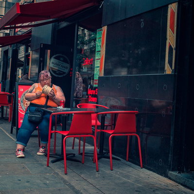 Are you woman eating ice cream outside a shop Soho London colour photography