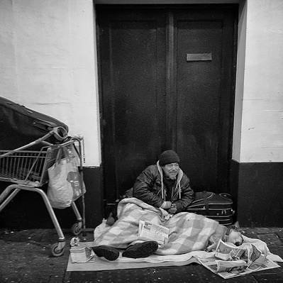Rough sleeper with his dog keeping warm, London black-and-white photography