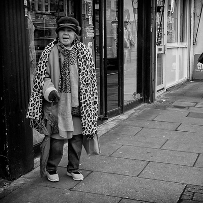 Lady standing outside a shop in Tooting South London black-and-white photography