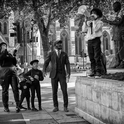 'Family taking photograph of son next to Nelson Mandella Statute, Black Lives Matter Protests, London Black and White Street Photography'