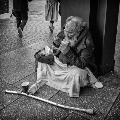 Rough sleeper eating his dinner, Tooting black-and-white photography