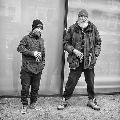 Too hard men beer in hand Tooting Broadway, south London black-and-white photography