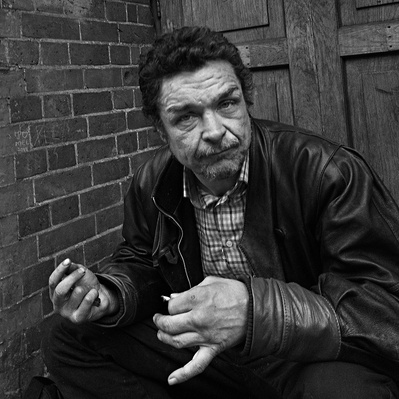 Rough sleeper sitting in doorway, London black-and-white photography