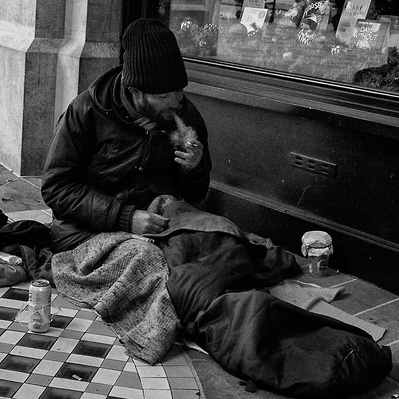 Rough sleeper having a smoke in London black-and-white photography