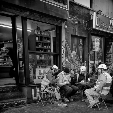 A group of construction workers sitting outside a café in the elephant and Castle south London black-and-white photography