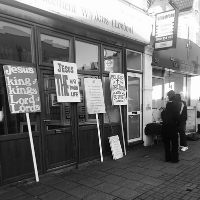 A bunch of placards up against a window Tooting South London black-and-white photography