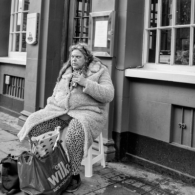 Lady having a rest outside a pub, South London black-and-white photography